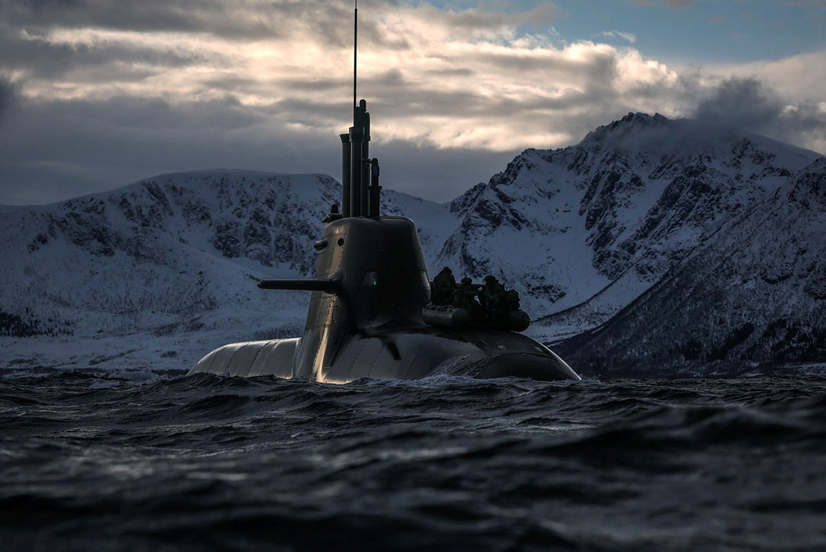 Submarine at sea in front of snow-covered mountains